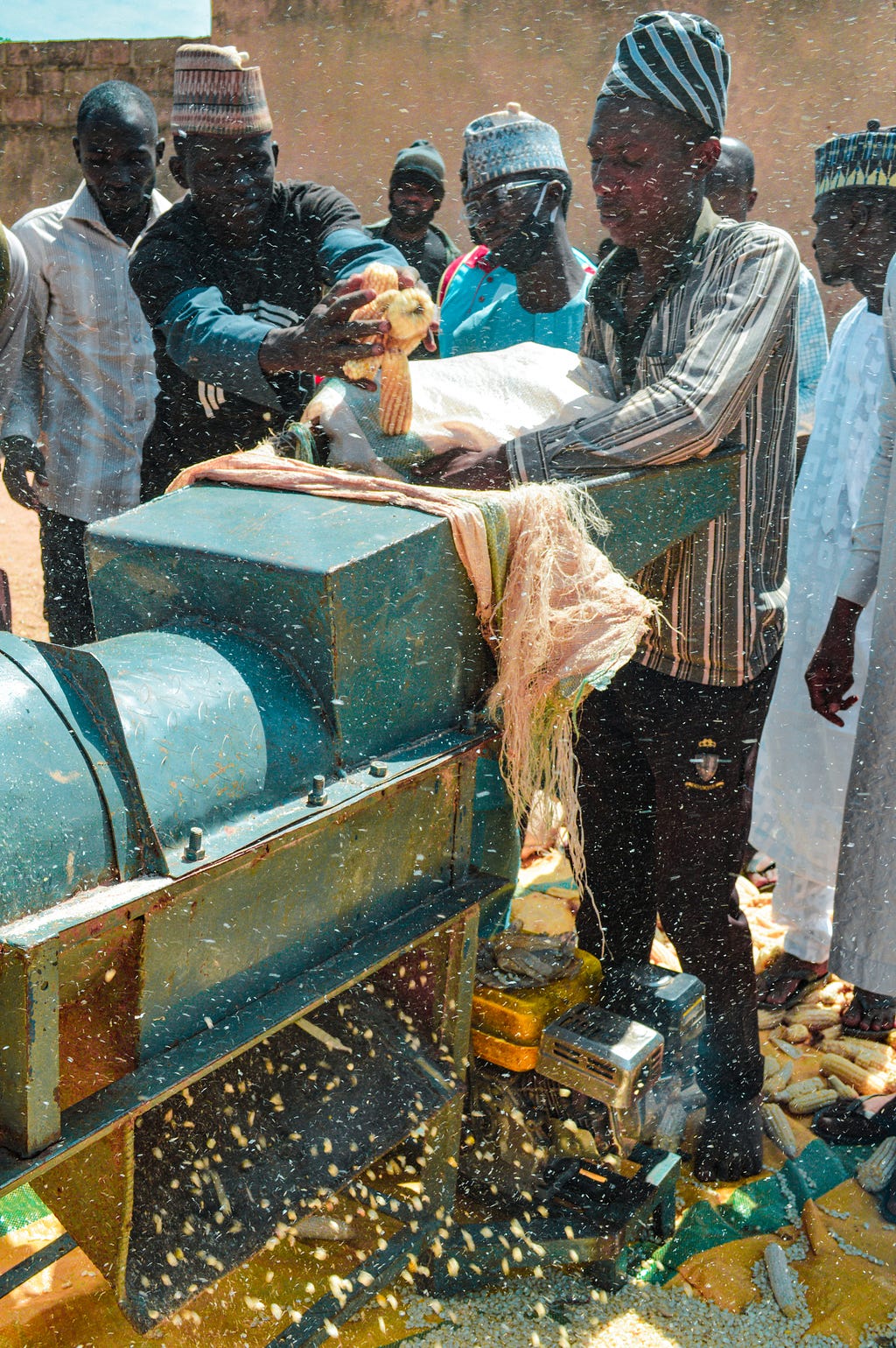 Farmer loading the Threshing machine with maize cobs in Kankara, Katsina.