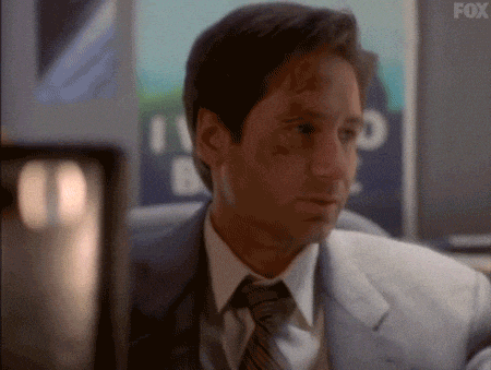 GIF of a frustrated Fox Mulder from the X-Files, who believes in government conspiracy theories, with an "I want to believe" poster behind him.