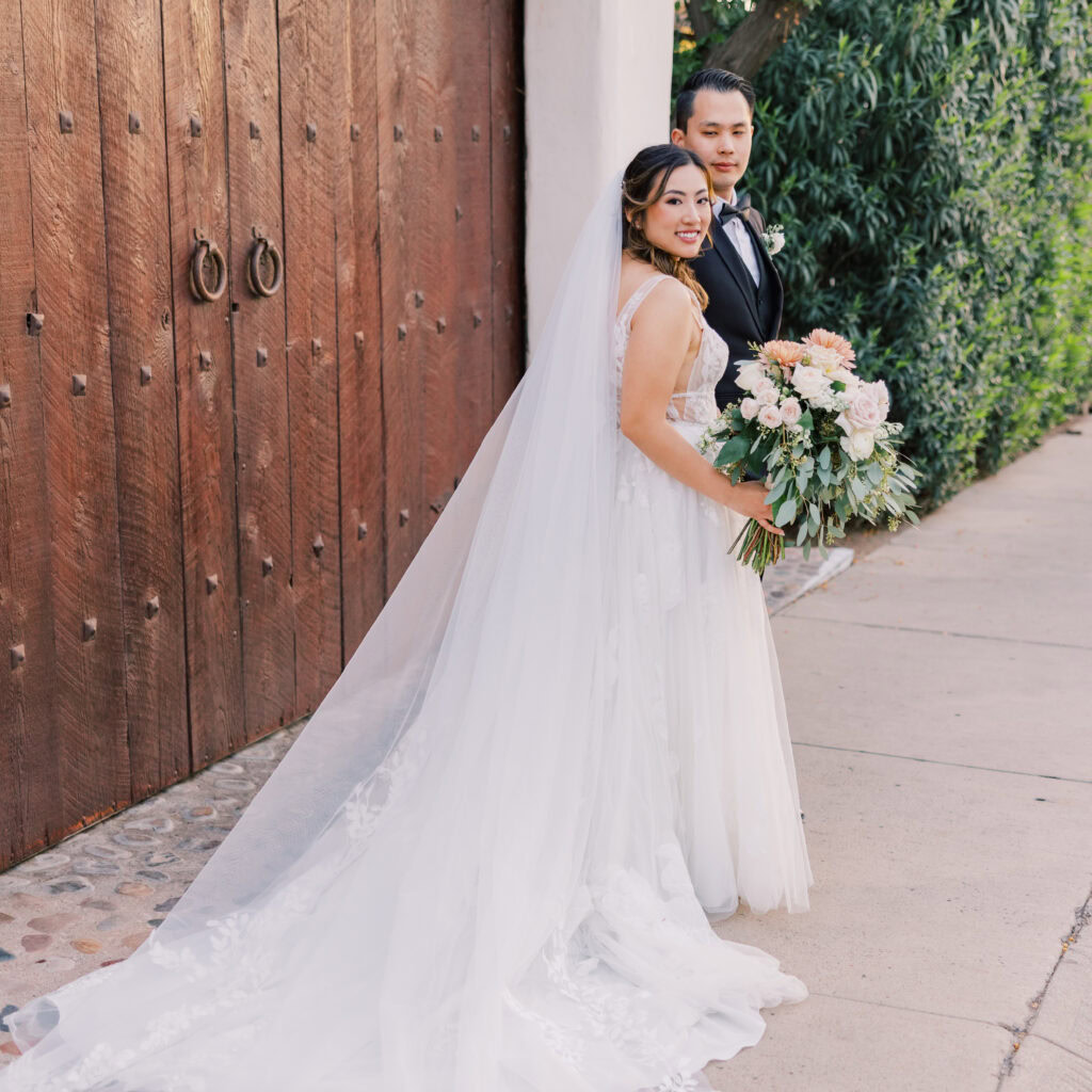 Bride and Groom smile as they walk along the streets of downtown Tucson, Arizona after their wedding at the Stillwell House wedding venue.
