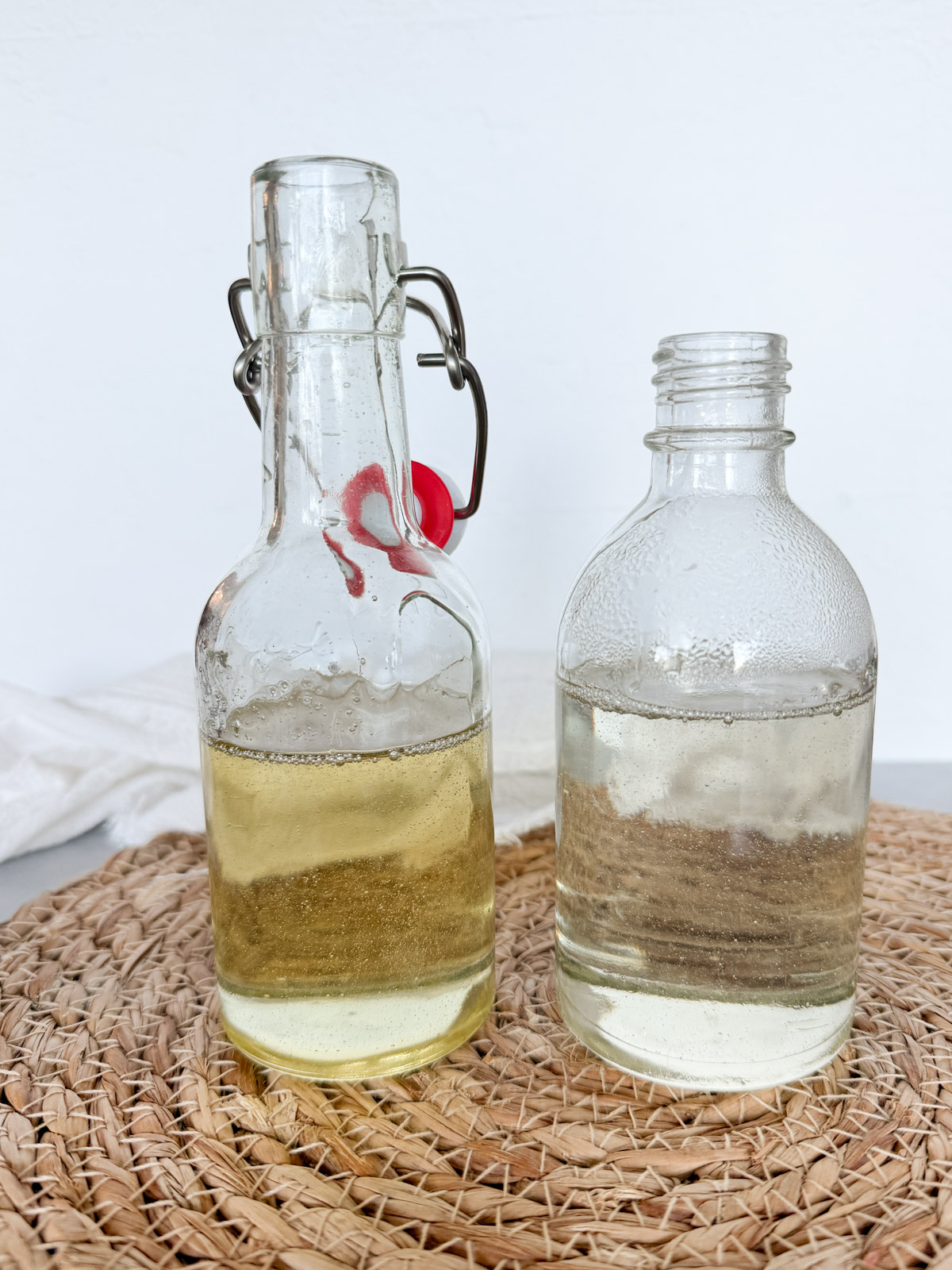two bottles of baklawa syrup one is clear and the other is yellow