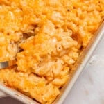 a spoon scooping chick fil a mac and cheese from a casserole dish.