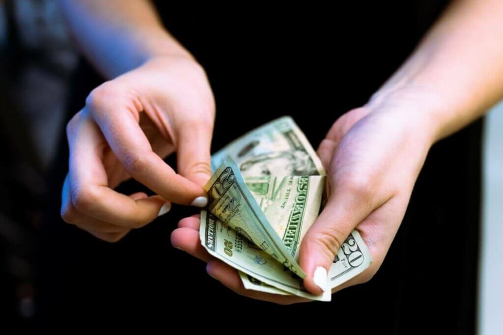A women's hands are counting cash.