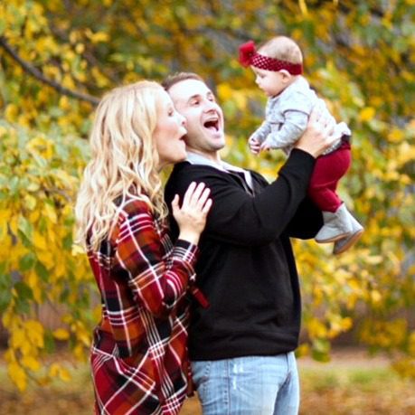 Happy adoptive couple playing with their baby outside