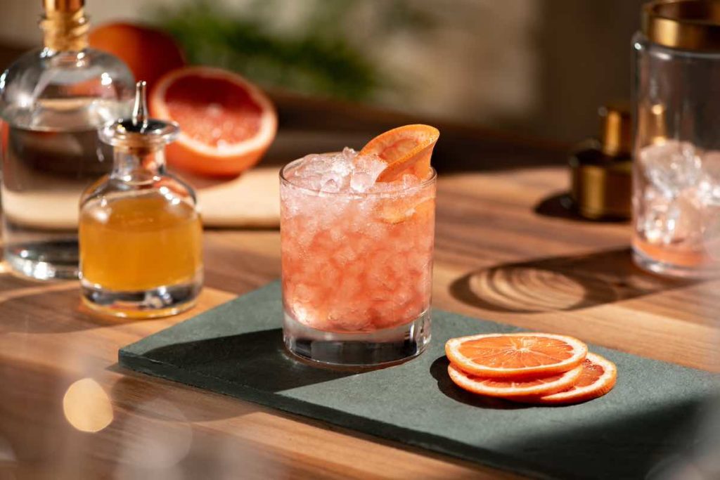 grapefruit smash cocktail in a rocks glass, garnished with a grapefruit slice