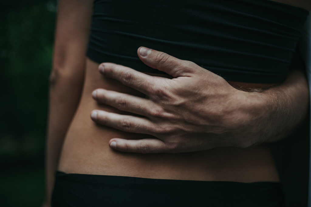 A person holding their stomach, representing the connection between gut health and mental health, including its role in reducing stress and anxiety.