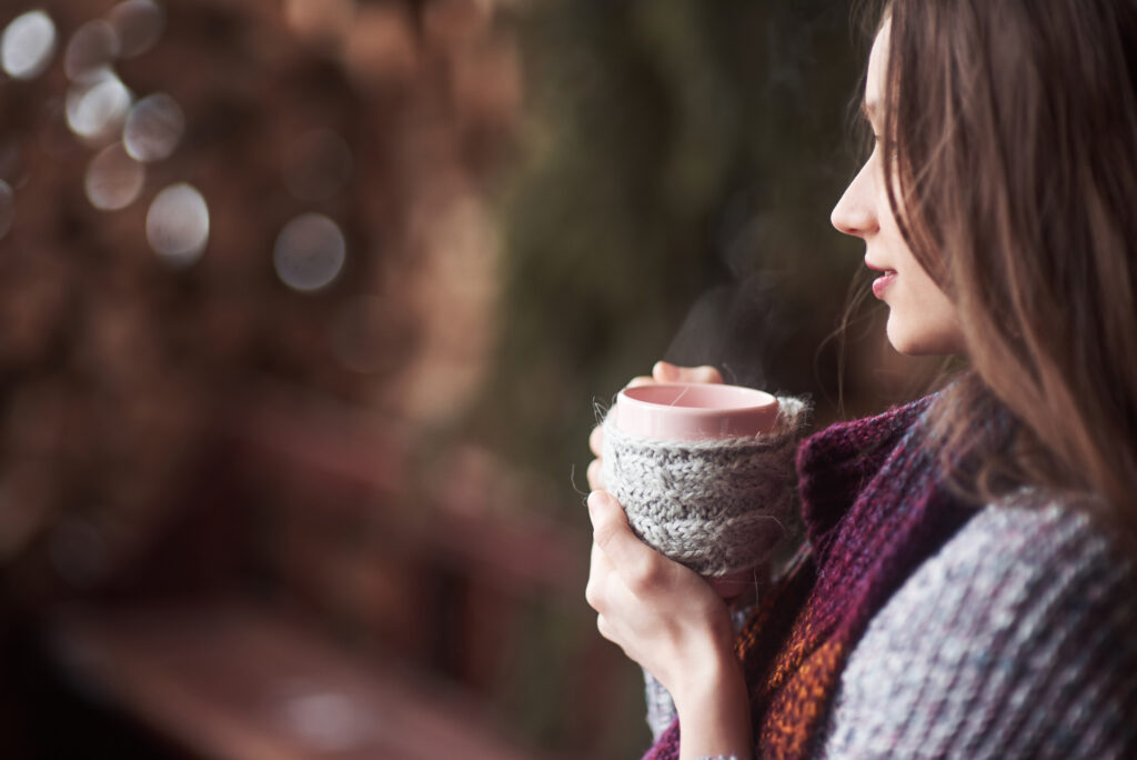 Woman pausing with a warm drink during women’s burnout recovery, finally choosing herself.