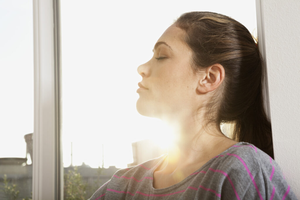 Woman standing in sunlight, finding hope and healing through women’s burnout recovery