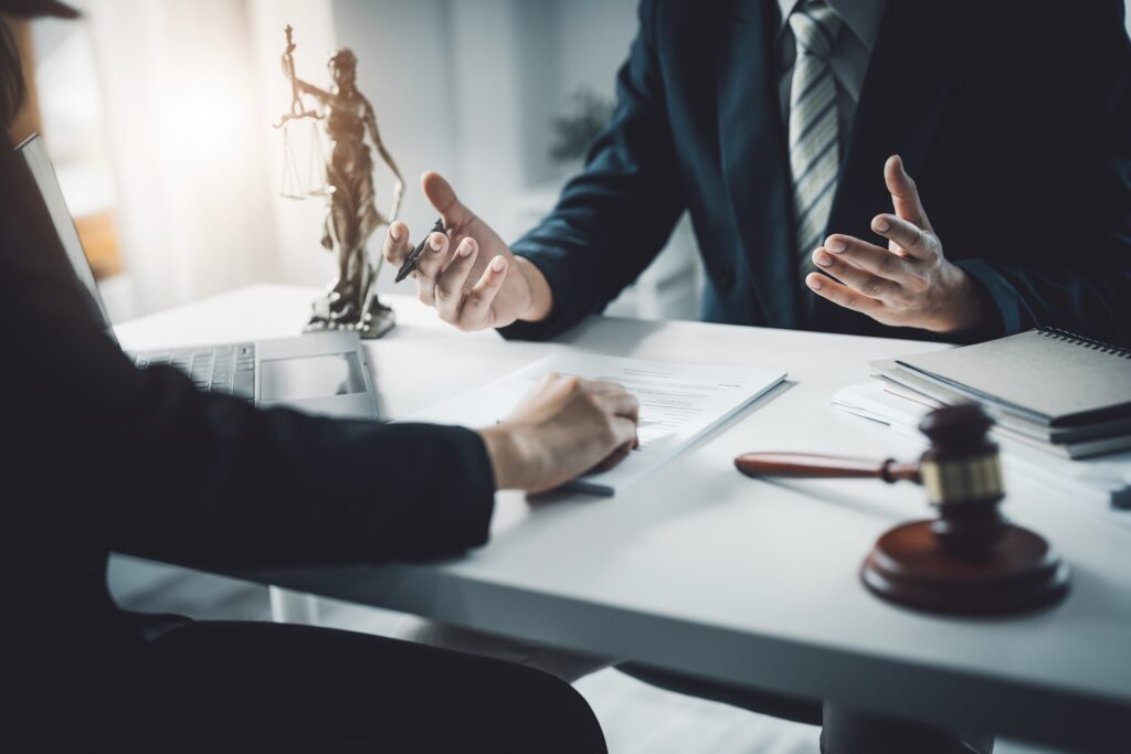 two people speaking at a desk with just their hands showing with a justice statue on the desk image for retirement blog post
